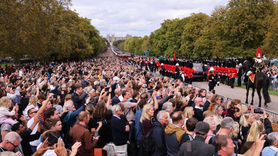 The Committal Service For Her Majesty Queen Elizabeth II WINDSOR, ENGLAND - SEPTEMBER 19: Mourners watch the State Hearse of Queen Elizabeth II as it drives along the Long Walk ahead of the Committal Service for Queen Elizabeth II on September 19, 2022 in Windsor, England. The committal service at St George's Chapel, Windsor Castle, took place following the state funeral at Westminster Abbey. A private burial in The King George VI Memorial Chapel followed. Queen Elizabeth II died at Balmoral Castle in Scotland on September 8, 2022, and is succeeded by her eldest son, King Charles III. (Photo by Richard Heathcote/Getty Images)