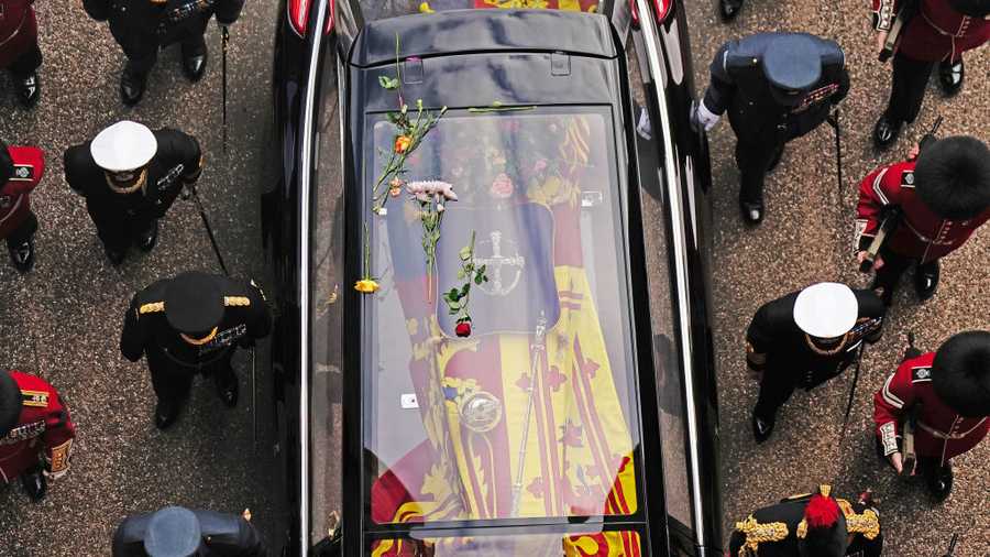 The Committal Service For Her Majesty Queen Elizabeth II WINDSOR, ENGLAND - SEPTEMBER 19: Flowers on the hearse carrying the coffin of Queen Elizabeth II as it arrives at Windsor Castle for the Committal Service in St George's Chapel on September 19, 2022 in Windsor, England. The committal service at St George's Chapel, Windsor Castle, took place following the state funeral at Westminster Abbey. A private burial in The King George VI Memorial Chapel followed. Queen Elizabeth II died at Balmoral Castle in Scotland on September 8, 2022, and is succeeded by her eldest son, King Charles III. (Photo by Aaron Chown - WPA Pool/Getty Images)