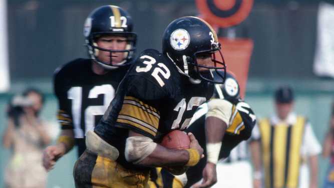 Pittsburgh Steelers quarterback Terry Bradshaw #13 hands off to his running back Franco Harris #32 circa 1970's. Pittsburgh Steelers quarterback Terry Bradshaw #13 hands off to his running back Franco Harris #32 circa 1970's.